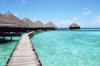 A luxurious overwater resort in the Maldives with wooden bungalows and crystal clear ocean waters