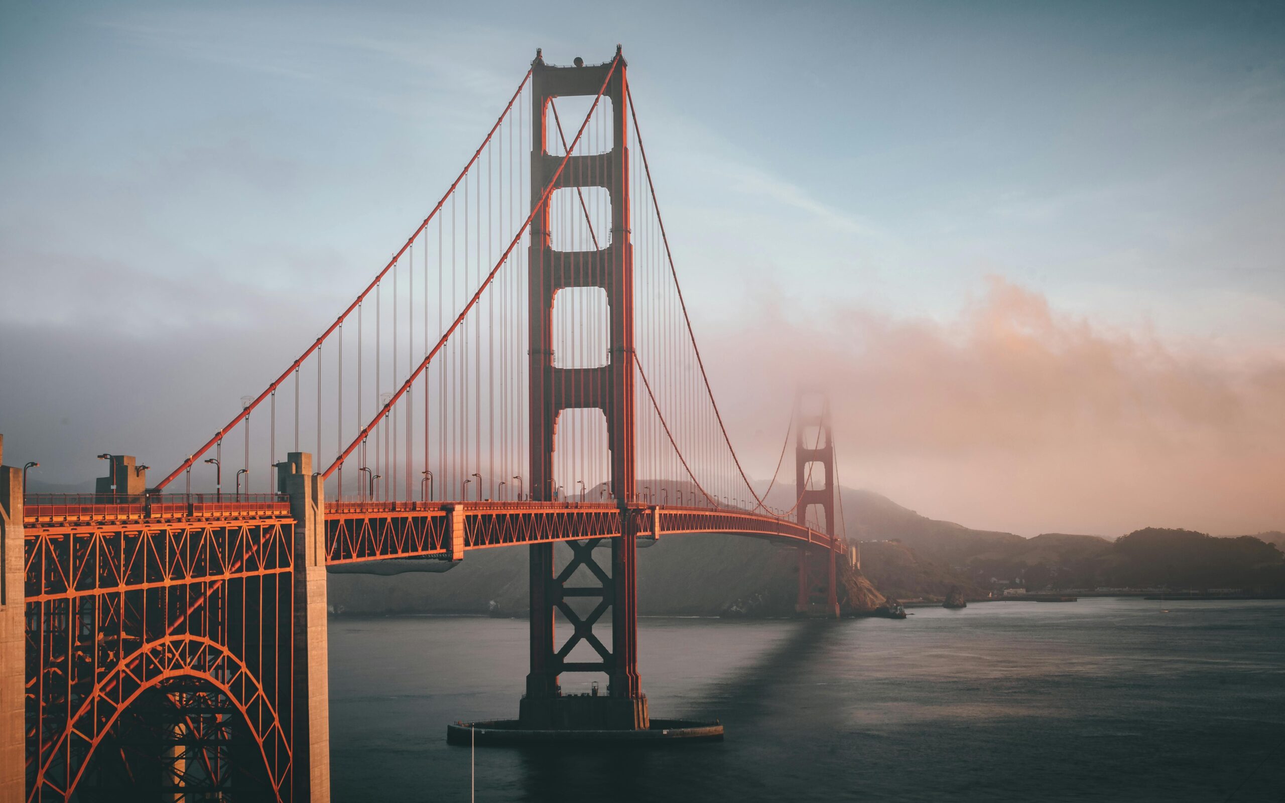 Golden Gate Bridge in San Francisco, California, spanning across the bay with iconic red towers and a scenic backdrop of sky and water