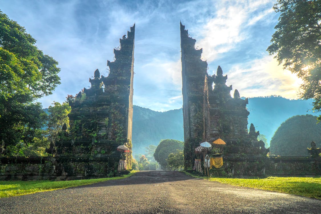 Traditional Balinese split gate at Handara Gate in Bali, surrounded by lush greenery and mountains during sunrise