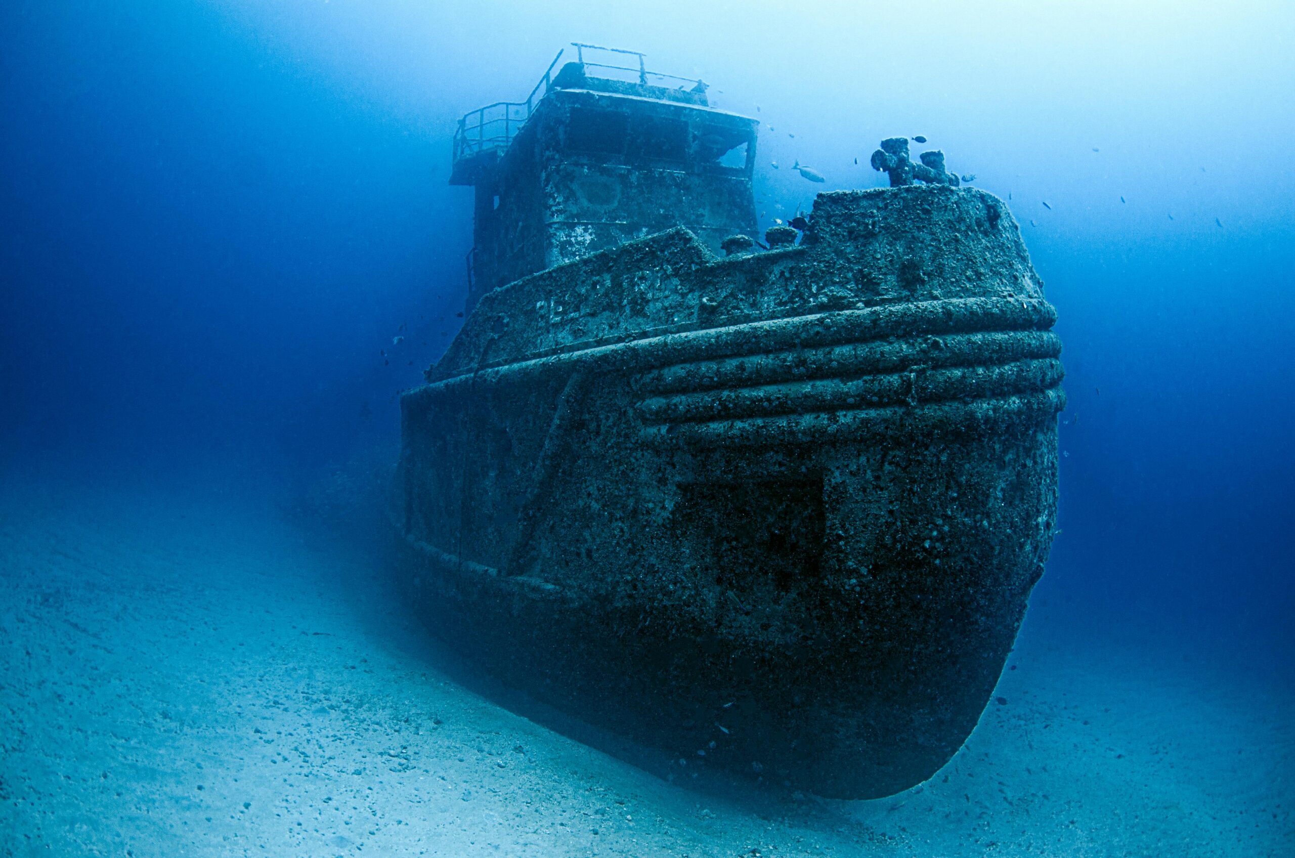 Sunken WWII shipwreck covered in coral resting on the seafloor, a popular scuba diving site in Guam, Pacific Ocean