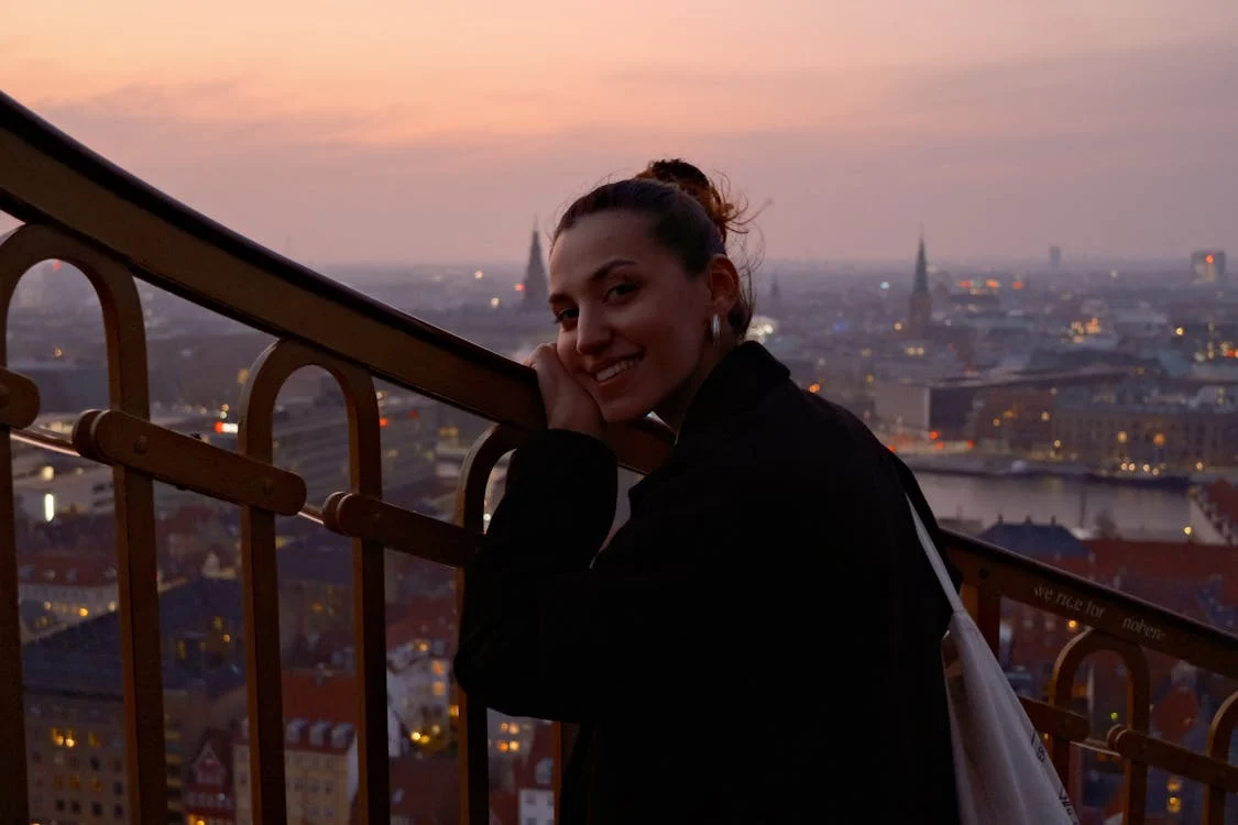 Solo traveler enjoying sunset views over a European city skyline on a budget trip