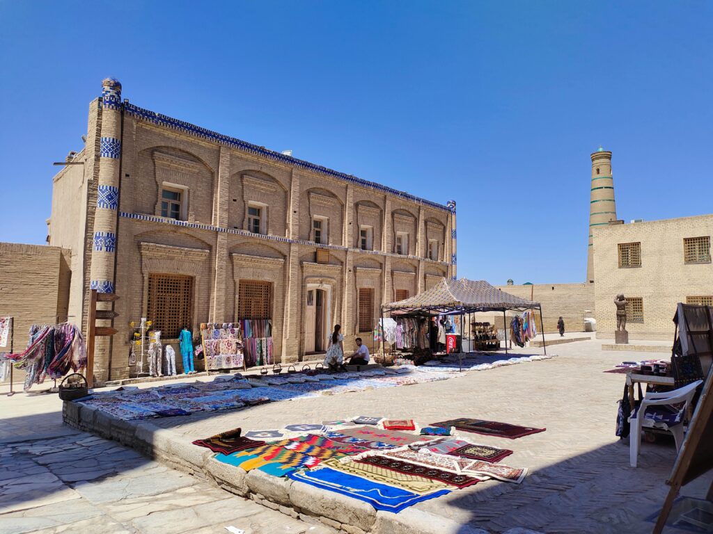 Local street market in Khiva, Uzbekistan with traditional handicrafts and historic Islamic architecture in the old town