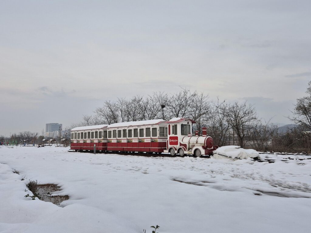 KTX high-speed train traveling through a snowy winter landscape in South Korea, surrounded by frosty trees