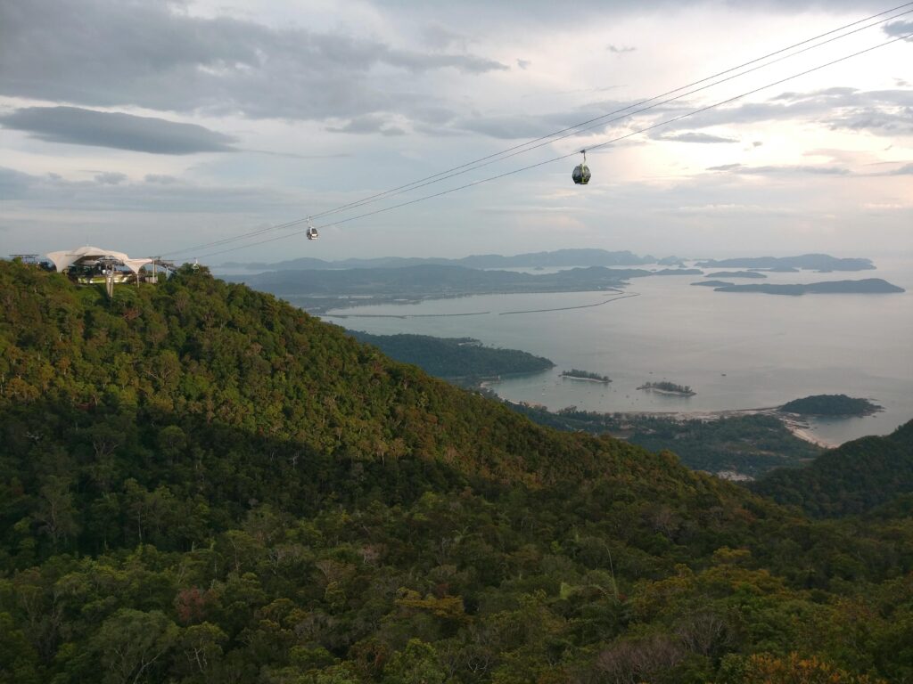 Langkawi Cable Car gliding above lush mountains with panoramic views of the ocean and blue sky in Langkawi, Malaysia
