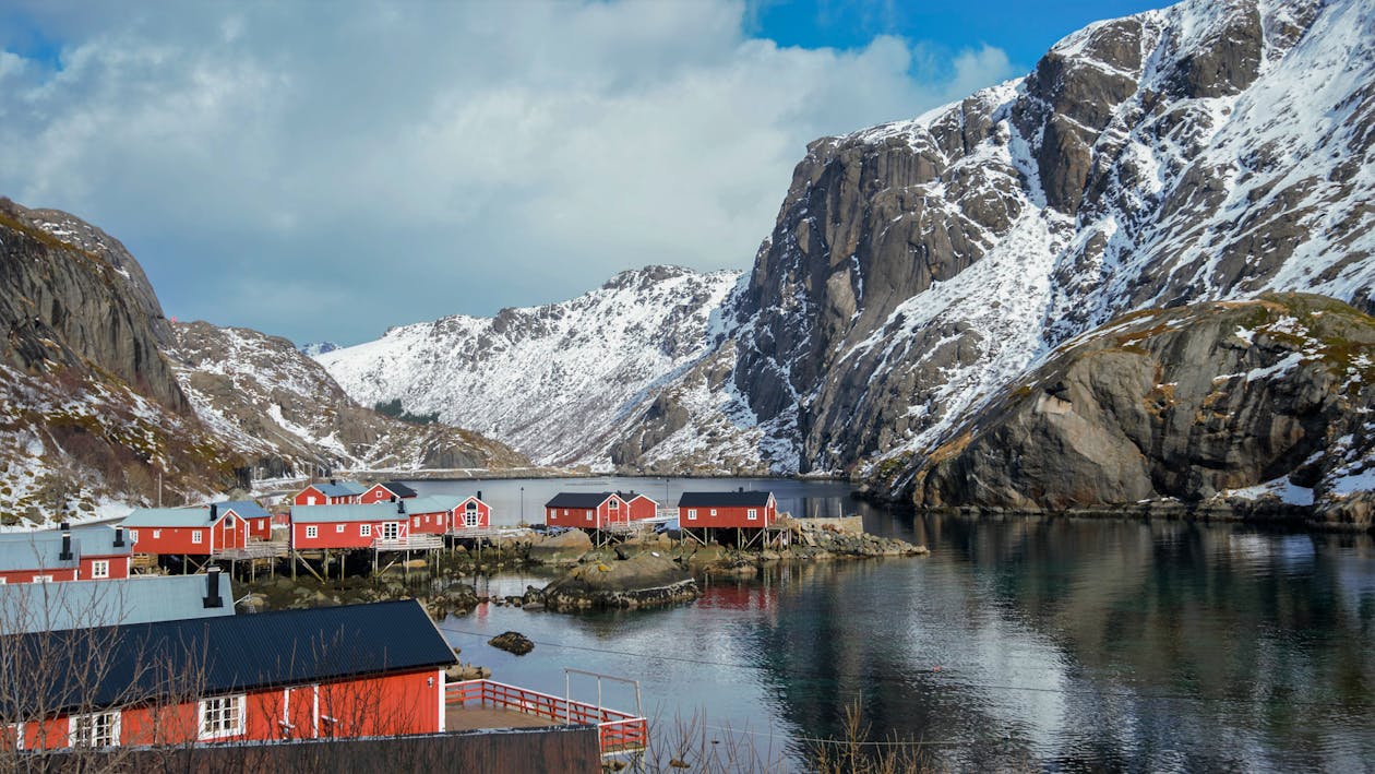 Best places to visit in Norway - Lofoten Islands' red fishing cabins against mountain backdrop