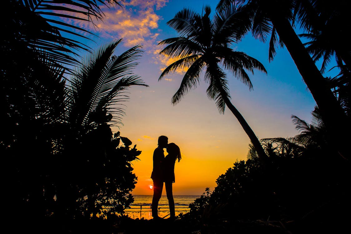 Stunning sunset over a Maldives beach with golden skies reflecting on crystal-clear ocean waters