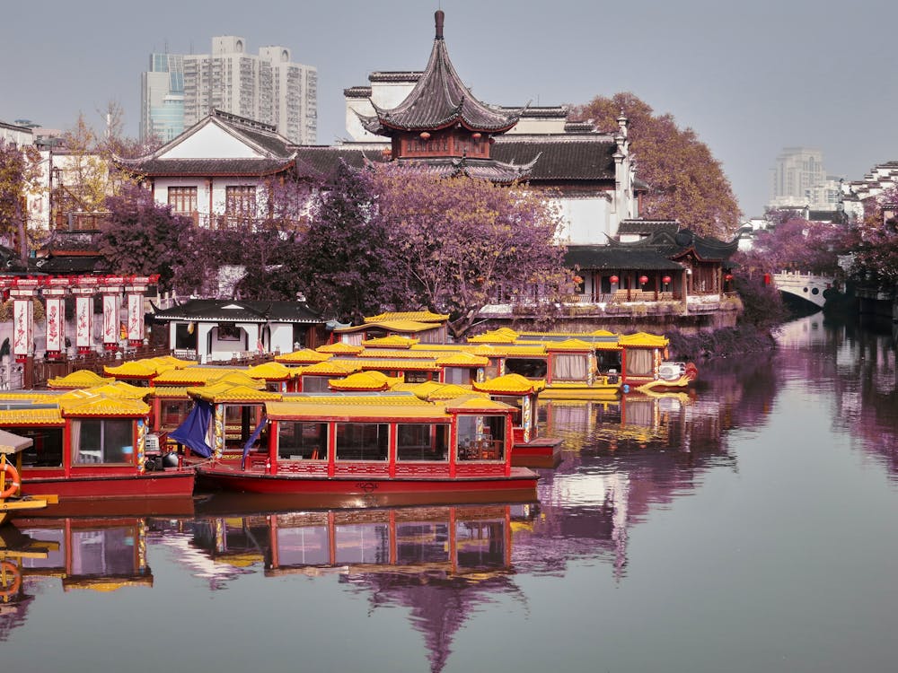 Traditional Chinese boats with yellow canopies on a peaceful canal surrounded by historic architecture in a preserved cultural district of China