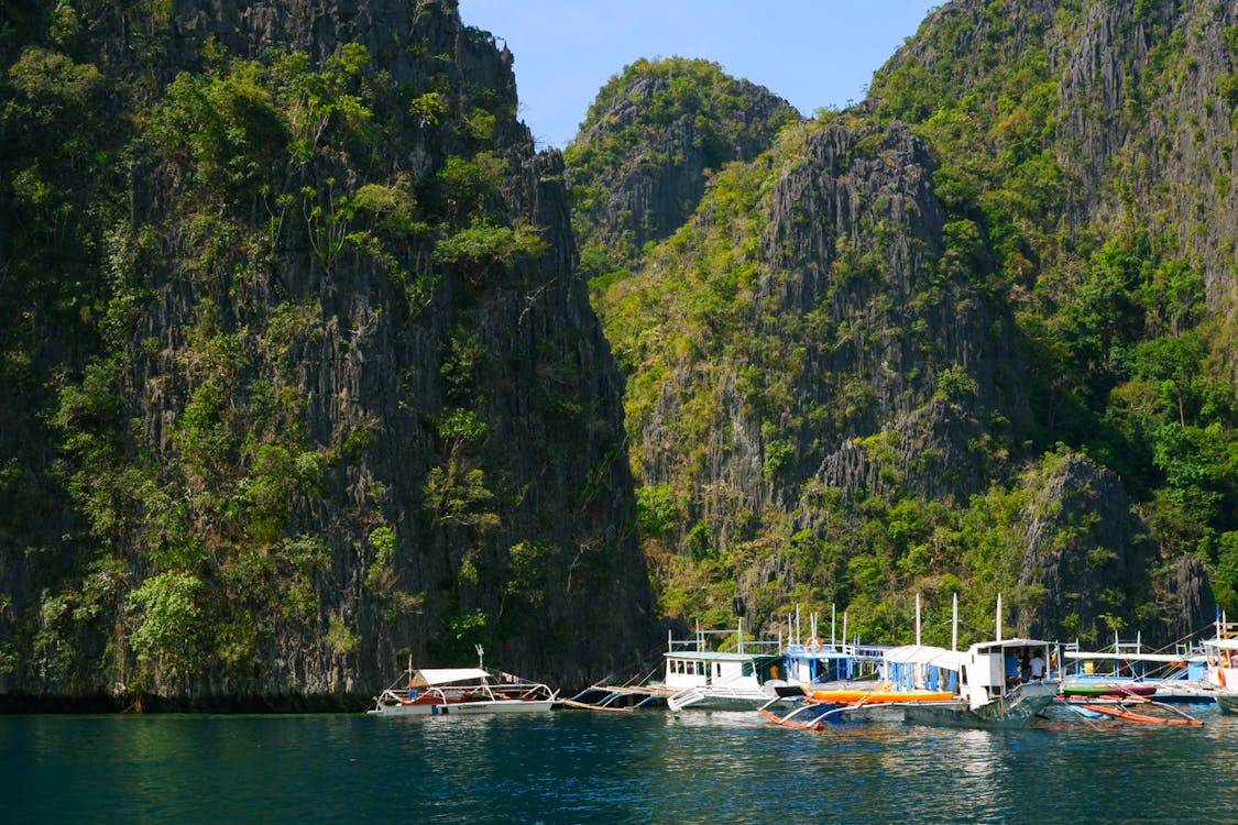 Boats anchored near the islands of the Palawan Archipelago, surrounded by crystal-clear waters and lush tropical scenery.