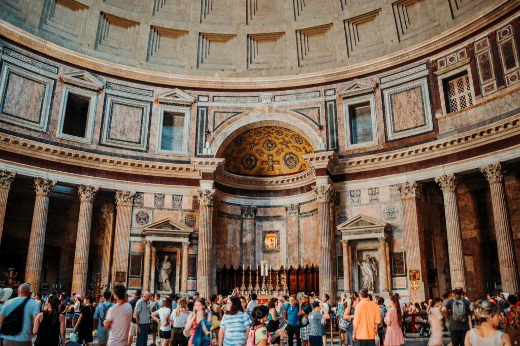 Crowded interior of the Pantheon in Rome, Italy, showcasing its iconic dome, ancient architecture, and visiting tourists