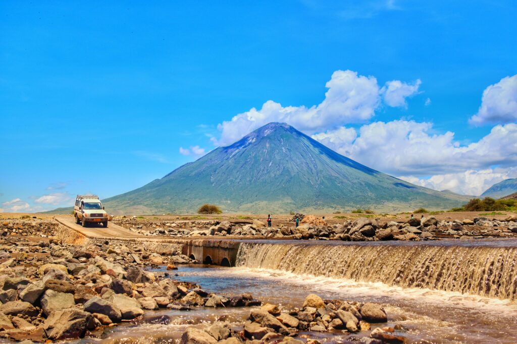 Safari vehicle crossing river during game drive on first solo trip to Africa