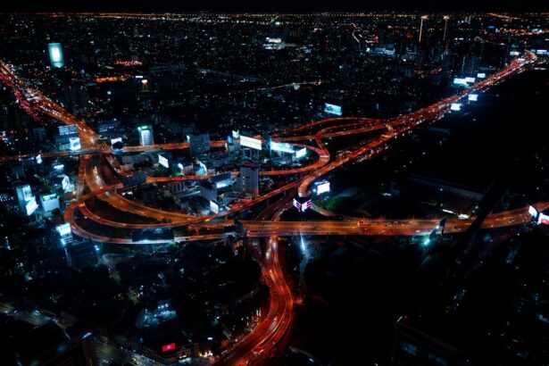 A nighttime view of Bangkok with illuminated avenues and towering skyscrapers in the city center.