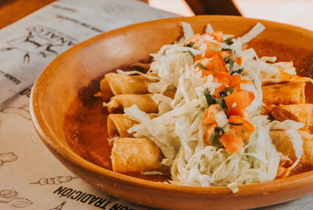 Traditional Mexican enchiladas with sauce and garnishes - best local foods to try in Mexico