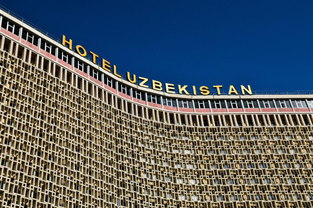 Exterior view of Hotel Uzbekistan in Tashkent with unique Soviet-era architecture against clear blue sky