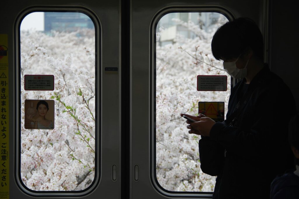 Solo traveler using translation app on smartphone in Tokyo, showing digital tools for solo travel to Japan