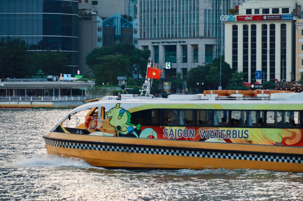 Saigon Waterbus cruising along the Saigon River in Ho Chi Minh City, offering scenic views of the urban skyline and riverside life