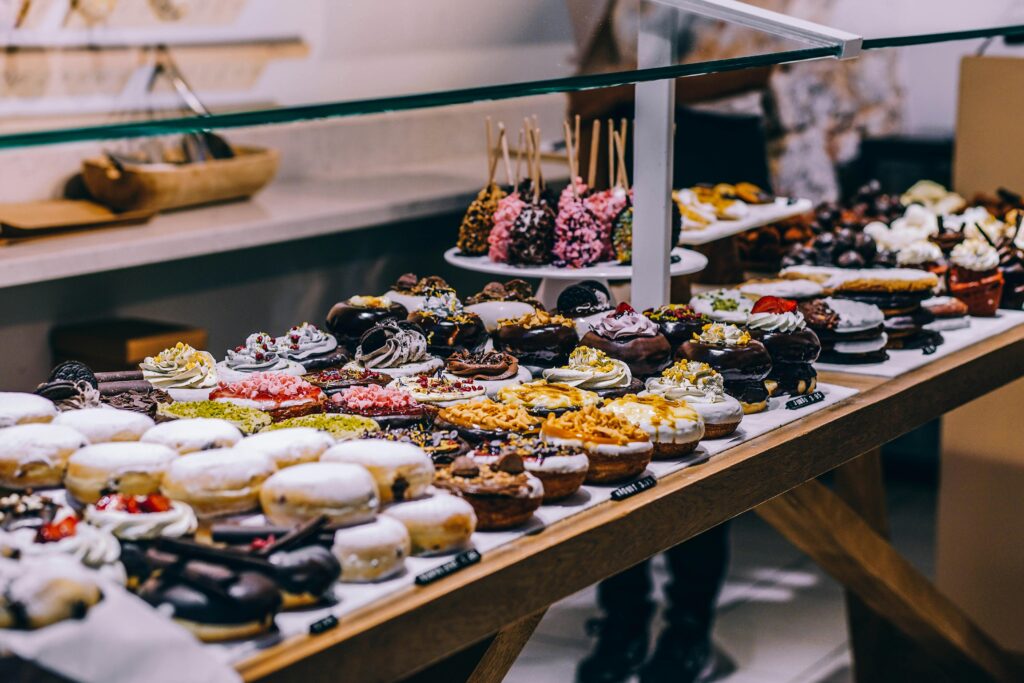 Colorful display of gourmet donuts and artisanal sweets at a dessert shop in Spain, showcasing a variety of toppings and creative flavors