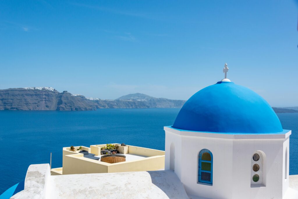 Best places to visit in July - Santorini's white and blue architecture against Mediterranean waters