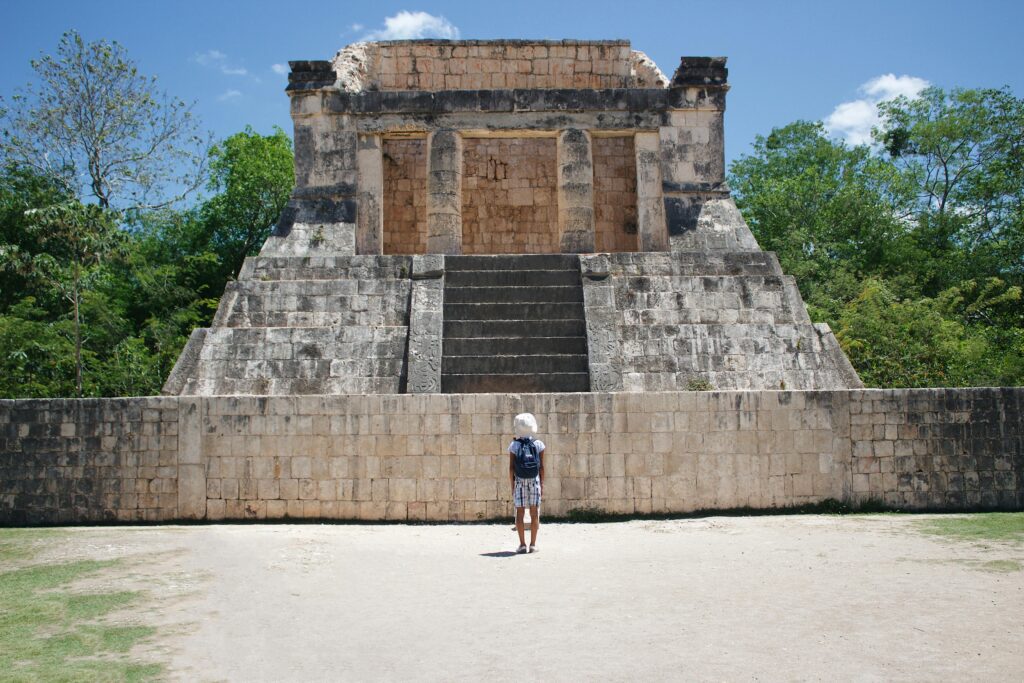 Visitor standing in front of an ancient Mayan temple at Chichén Itzá, Yucatán, Mexico