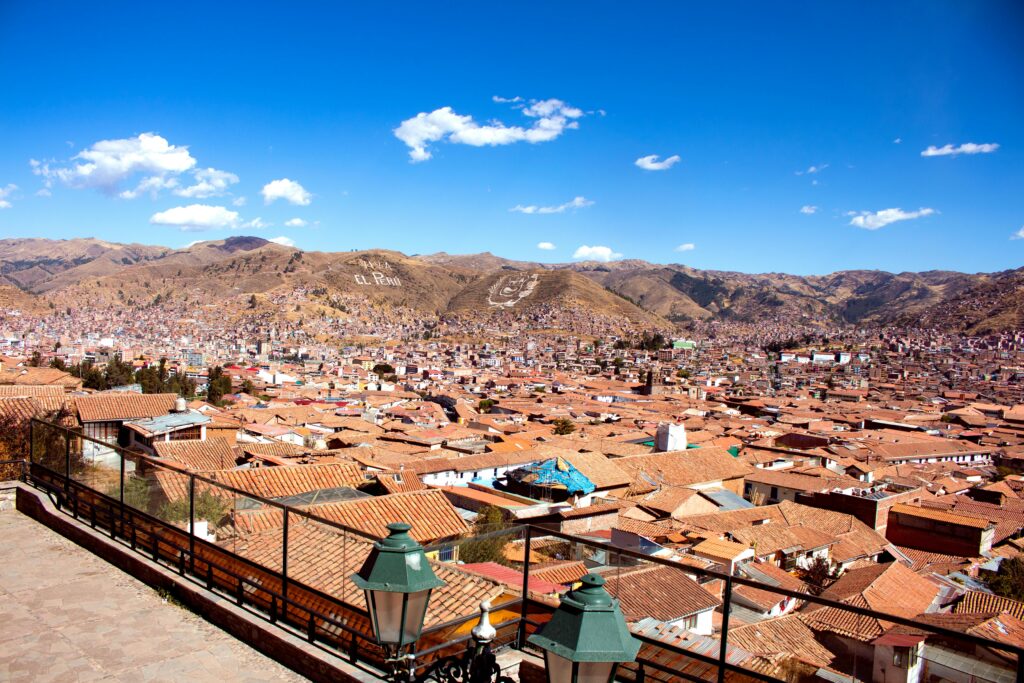 Cusco city in Peru with red roofs and mountains behind