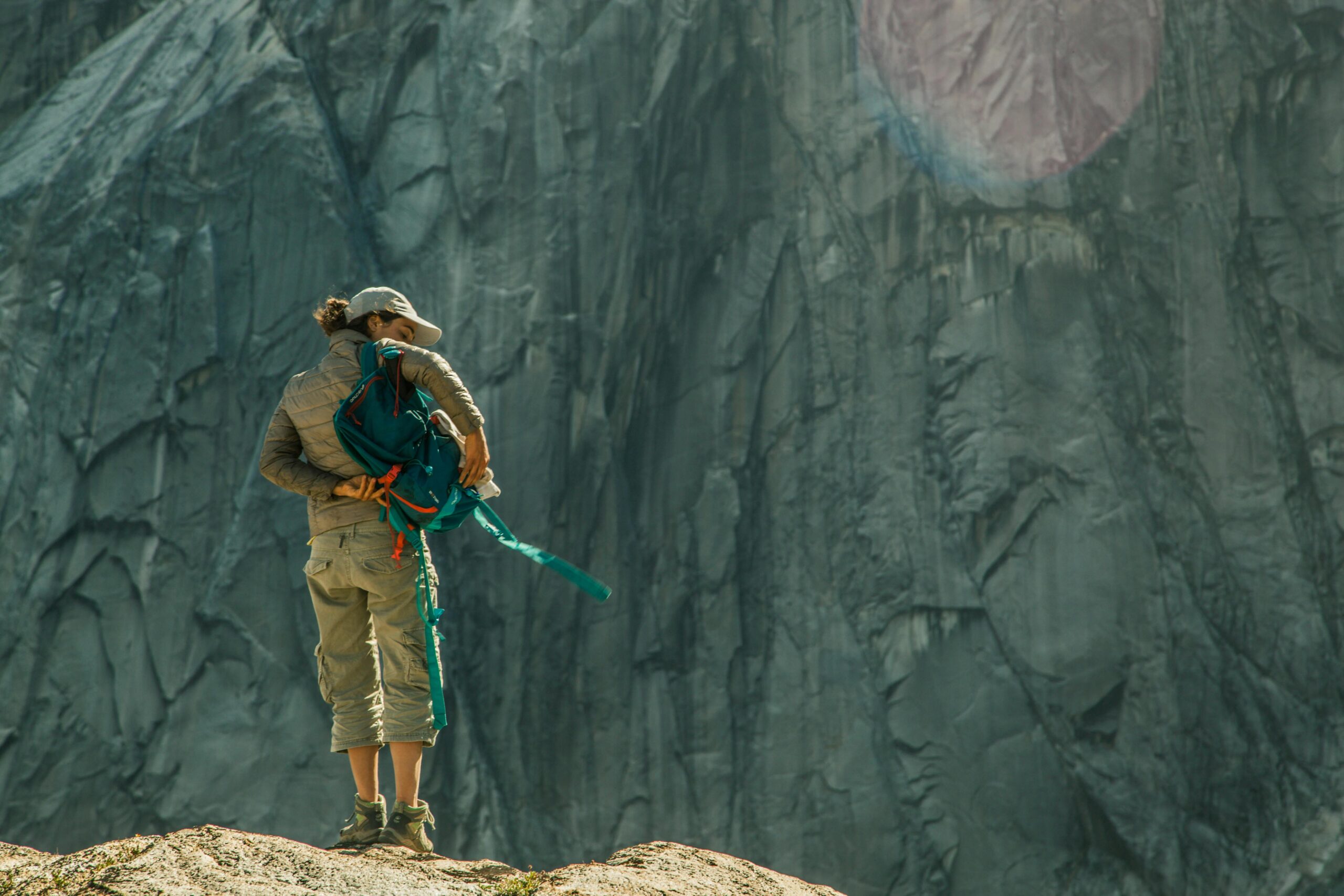 Traveler in Patagonia tightening backpack straps while hiking in windy conditions