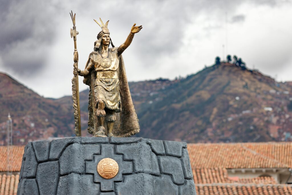 Statue of an Inca ruler in Cusco, Peru with mountains in the background-what to see in Machu Picchu