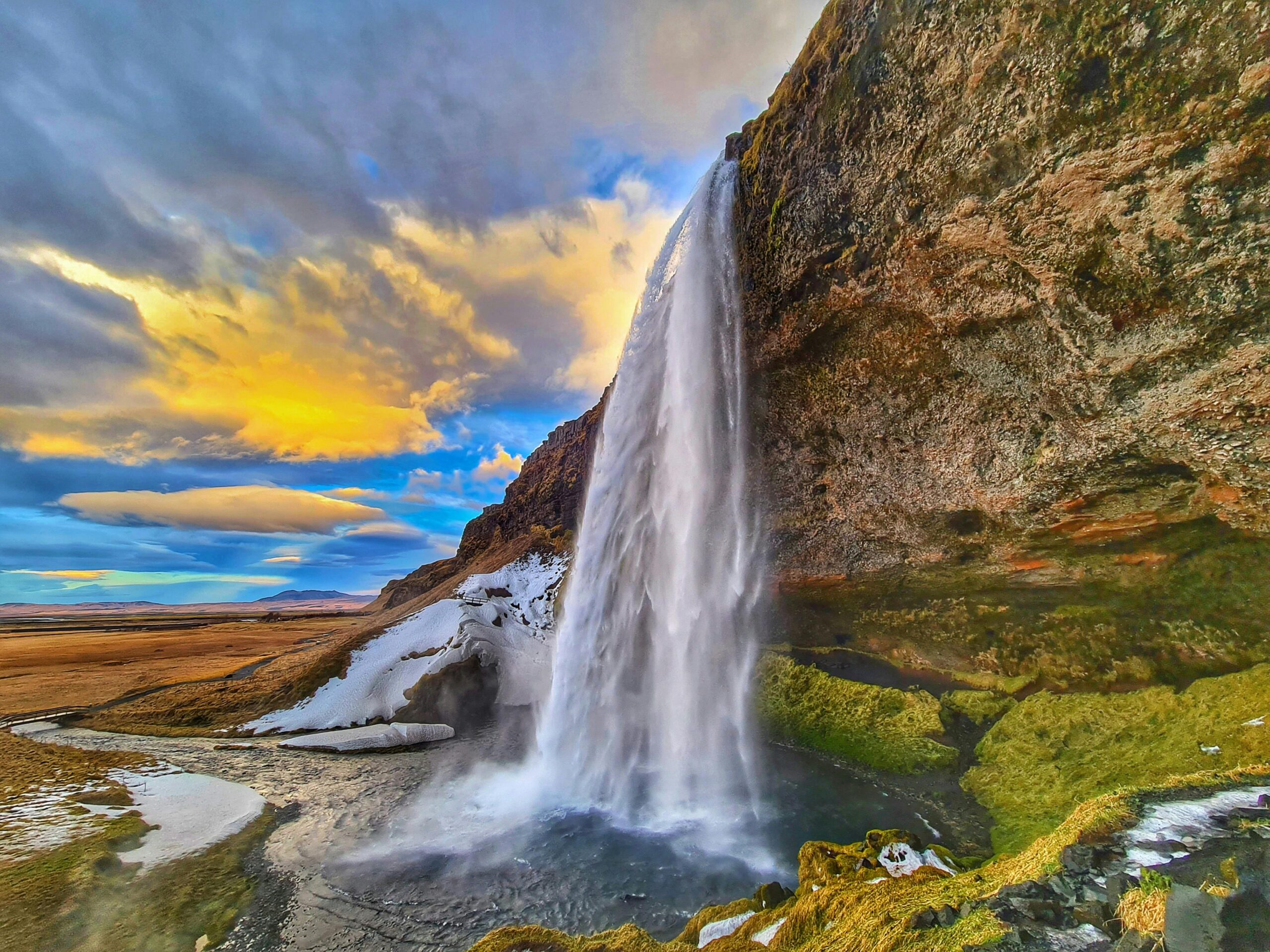 Seljalandsfoss waterfall in South Iceland at sunset with glowing mist