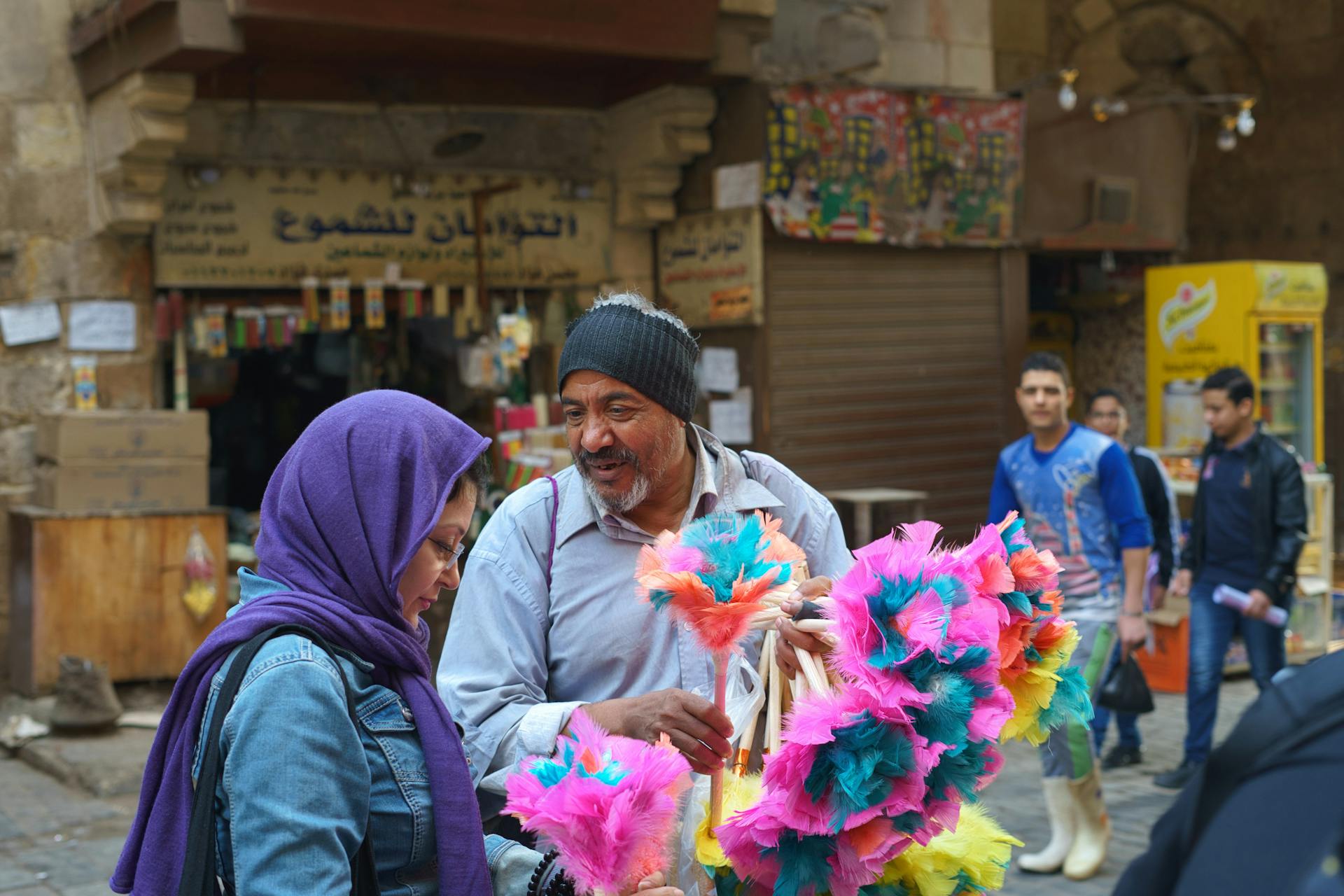 Local vendor and female tourist talking at a colorful street market in Cairo, Egypt