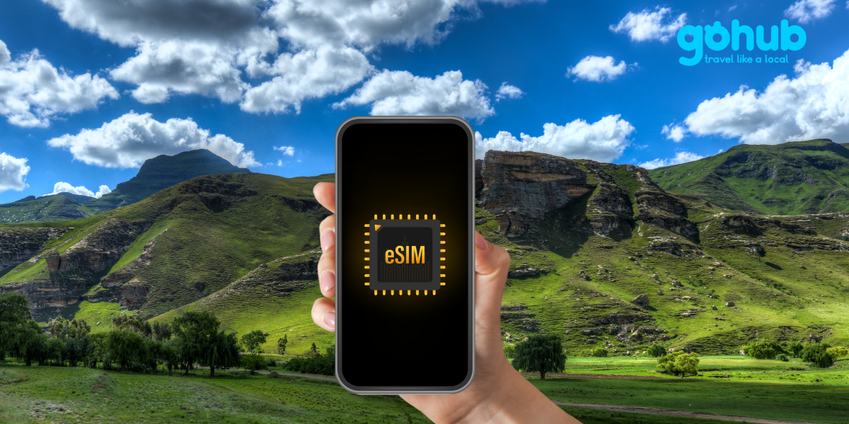 A hand holding a phone with an eSIM icon, set against the backdrop of Lesotho’s mountainous landscape.